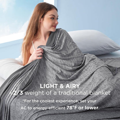 Woman wrapped in a lightweight, gray cooling blanket on a bed, noting 'Light & Airy, 2/3 weight'.