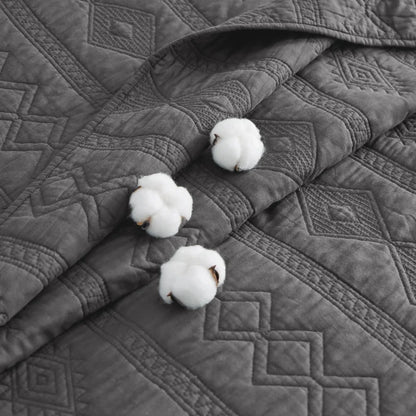 Close-up of grey 100% Cotton Voile Quilt Set featuring textured geometric pattern and cotton bolls.