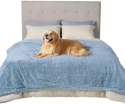 Happy Golden Retriever on plush light blue waterproof pet blanket on bed, showcasing comfort and texture.