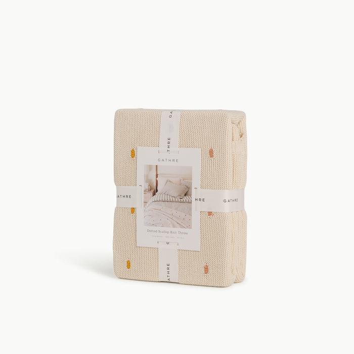 Ivory@Cotton knit throw blanket with dotted texture and scalloped edge in packaging
